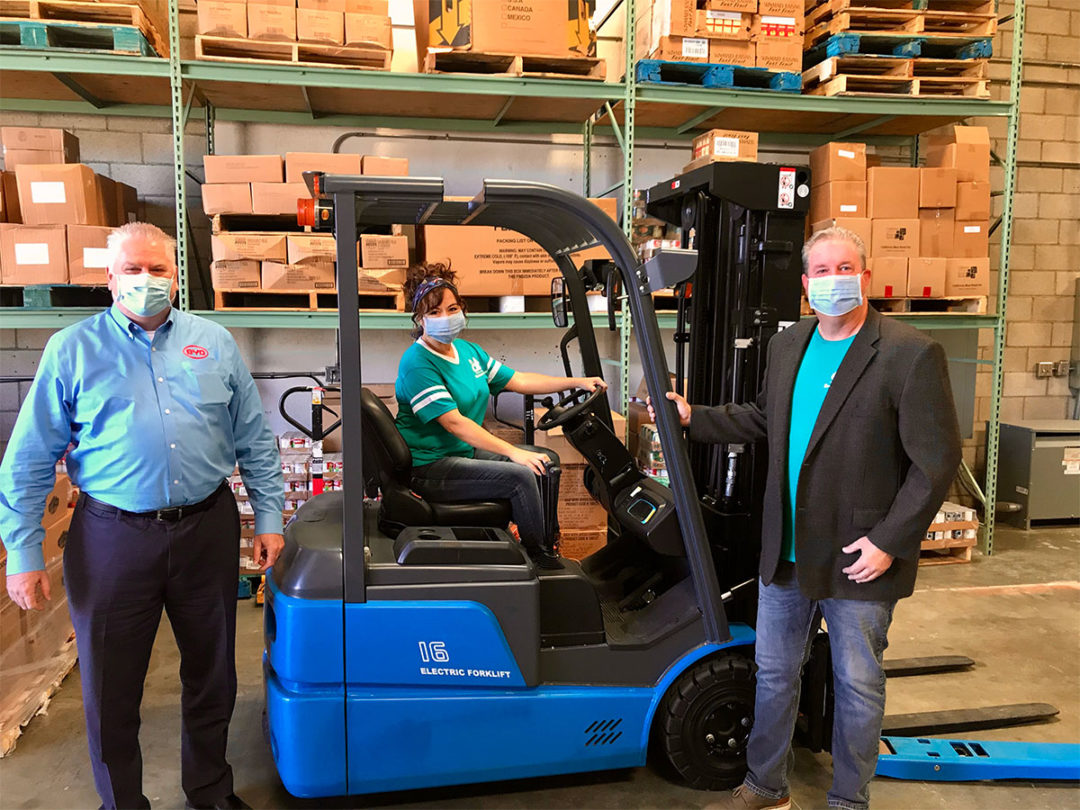 BYD and food bank employees in warehouse with a BYD forklift