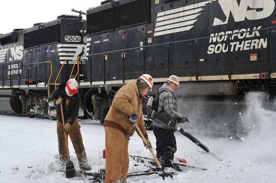 Workers clearing snow from train tracks