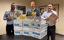 Transervice Logistics employees standing behind donated books