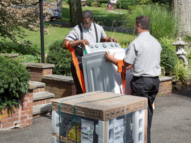 Two people delivering an appliance
