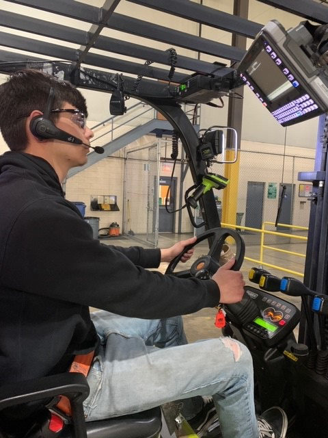 Person driving lift truck with voice headset