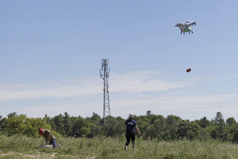 Drone making a delivery to people in a field