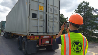 Man taking photo of container