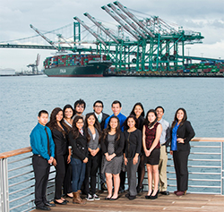 Students standing in front of ocean, cranes